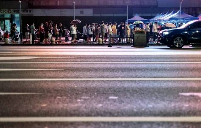 7月28日，南京街头一处核酸检测点，市民在夜色中排队，准备进行核酸检测取样。这是南京市第三轮全员核酸检测。摄影/本刊记者泱波