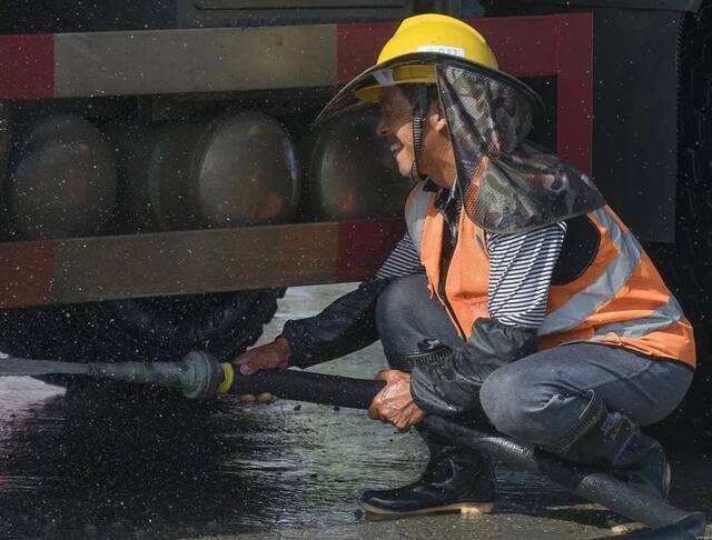 中建三局三公司重庆vivo项目，工人为货车冲洗排污。陈恒勇摄