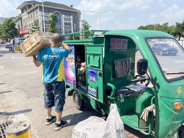 万州邮政投递员黄亮将邮件扛到肩上，汗水不停地从脸颊滑落到下颚。肖梦琳摄