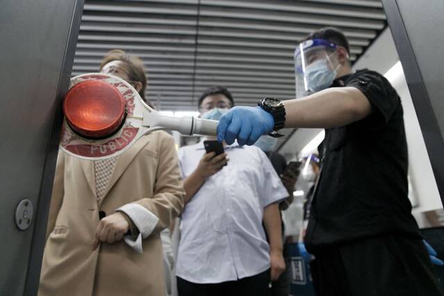 ▲8月5日，地铁天宫院站安检口，工作人员安排乘客分批入站。新京报记者尹亚飞王贵彬裴剑飞摄