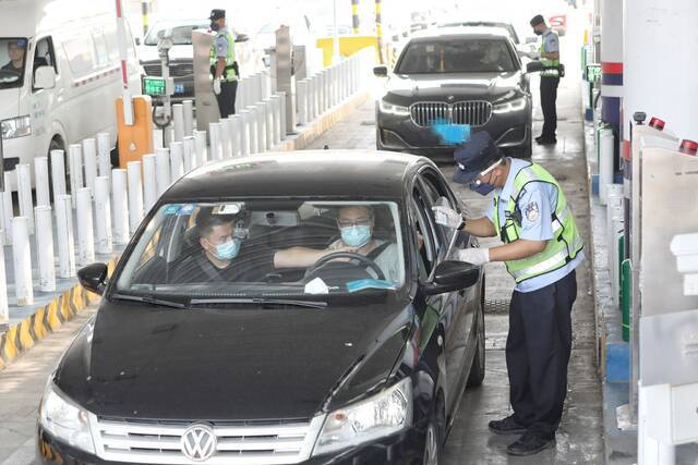 8月6日下午，房山区窦店公安检查站，警务人员在核查过往进京人员身份证和行程码。新京报记者王嘉宁摄