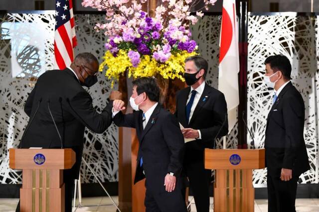 3月16日，在日本东京，美国国务卿安东尼·布林肯（右二）和国防部长劳埃德·奥斯汀（左一）与日本外务大臣茂木敏充（左二）和防卫大臣岸信夫在会晤后的联合记者会后碰肘致意。新华社发（Pool图片，野木一广摄）