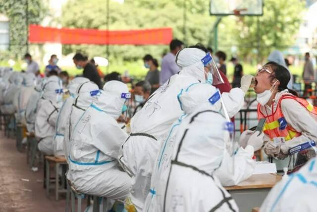 2021年8月7日，江苏扬州开展第四次全员核酸检测，图为邗江区邗江实验学校检测点，医生正在为居民进行核酸采样。图/IC