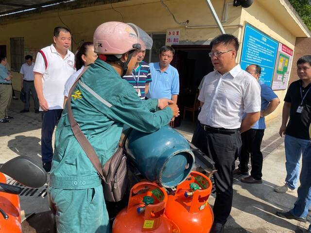 7月13日，柳州澳华加气站，一位用私人电动车运送煤气罐的员工接受国务院安委办明查暗访组询问。新京报记者苑苏文摄