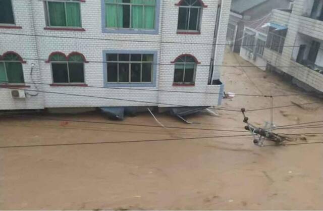 柳林镇洪水中的被冲倒的电线杆，一楼商户已被淹没。受访者供图