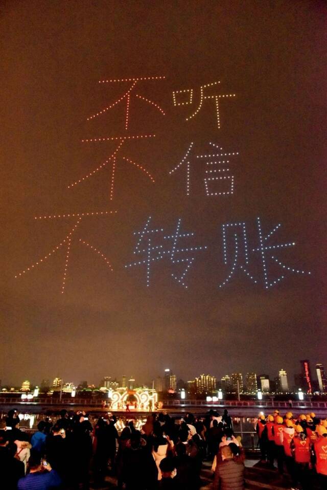 2月9日，江西南昌市的一场反电诈宣传中，无人机组成“不听不信不转账”的口号。图/人民视觉