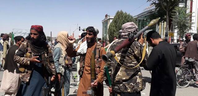 这张8月12日拍摄的照片显示塔利班武装人员在阿富汗东部加兹尼省首府加兹尼市街头行走。新华社发