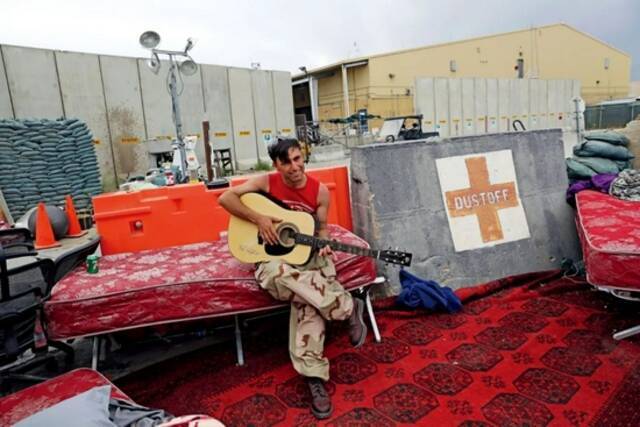 7月5日，阿富汗帕尔万省，美国和北约军队已从巴格拉姆空军基地全部撤离。一名阿富汗士兵弹奏着美军留下的吉他。