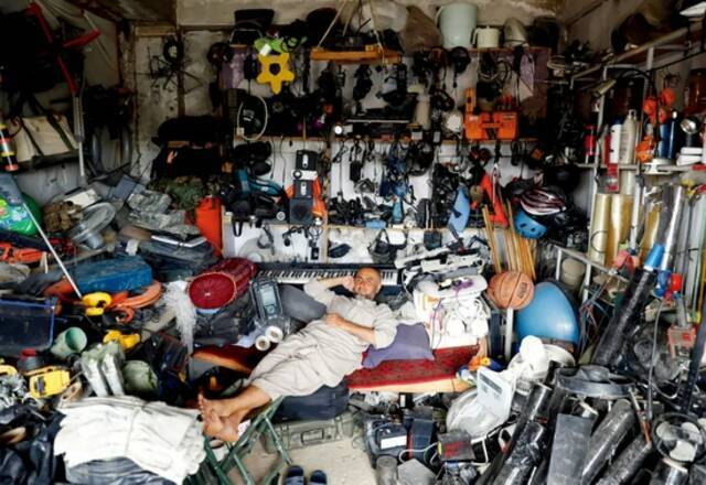  7月5日，巴格拉姆空军基地外，一名阿富汗男子在他的商店里休息。他的商店主要出售美国二手物资。本版图/澎湃影像