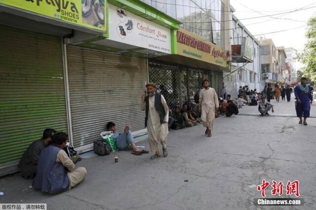 当地时间8月15日，阿富汗首都喀布尔，民众在一个集市排队，等待从附近银行取钱。