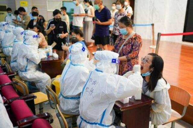 7月25日，市民在南京市建邺区兴隆街道香山路社区核酸检测点接受核酸检测取样。新华社记者李博摄