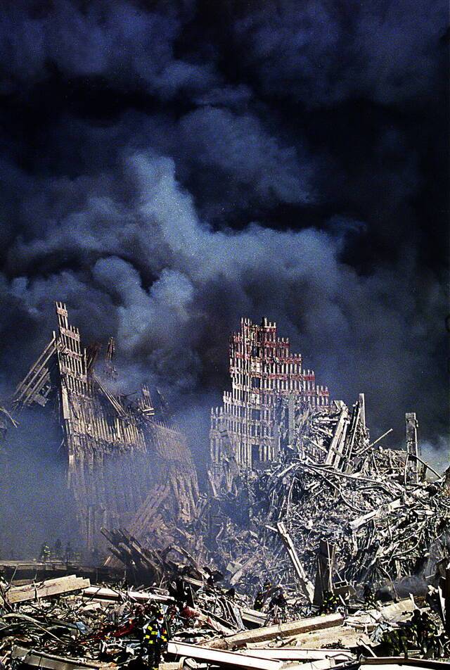  2001年9月11日，美国纽约，双子塔倒塌后，消防员在废墟中搜寻幸存者