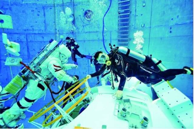 中国航天员中心航天员教员赵阳（右）在辅助航天员进行水下训练。孔方舟摄/光明图片