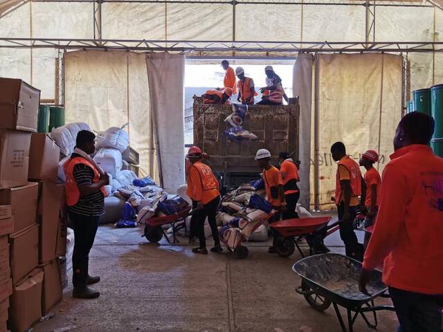 中企员工将海地华侨华人集资采购的物资装车运往灾区。图片由受访者提供