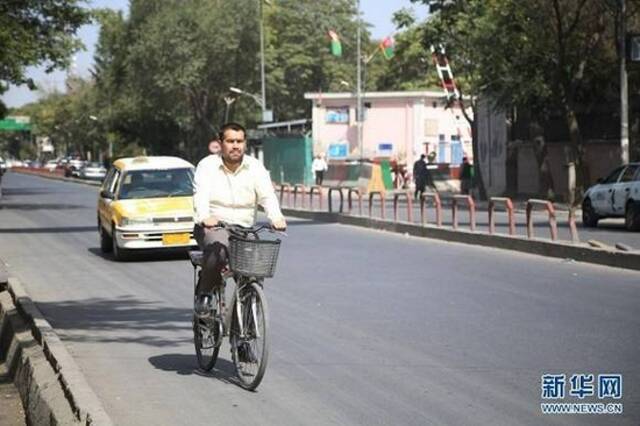 （图片说明：8月15日，一名男子在阿富汗首都喀布尔街头骑车出行。新华社发拉赫马图拉·阿里扎达摄）