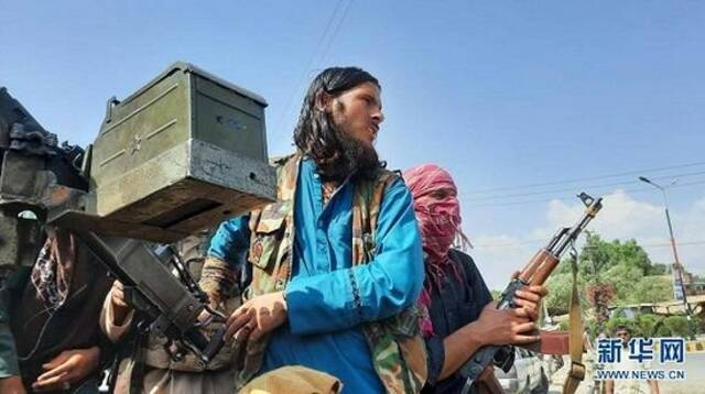 （图片说明：8月15日，塔利班武装人员在阿富汗拉格曼省米特拉姆街头乘车经过。新华社发）
