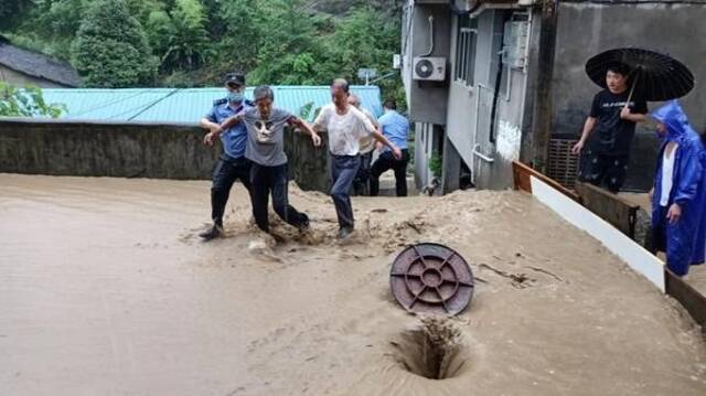 紫阳公安在雨中转移受困群众。西部法制报图