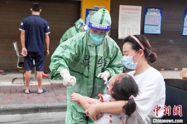 医务人员为居民进行手部消毒。杨华峰摄