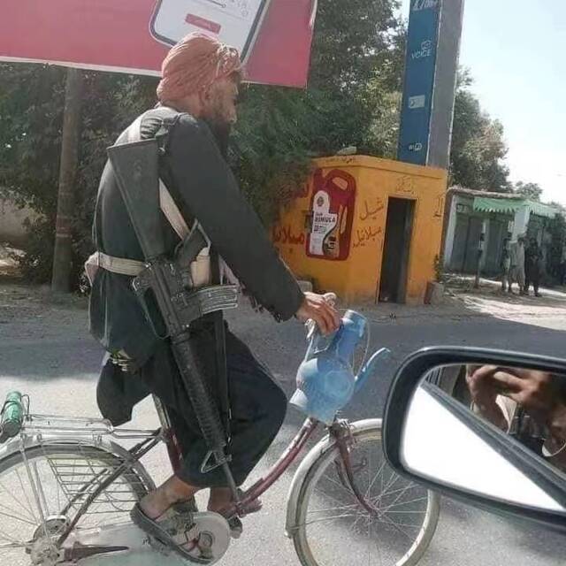 坎大哈街上穿着拖鞋，蹬自行车的塔利班成员。受访者供图