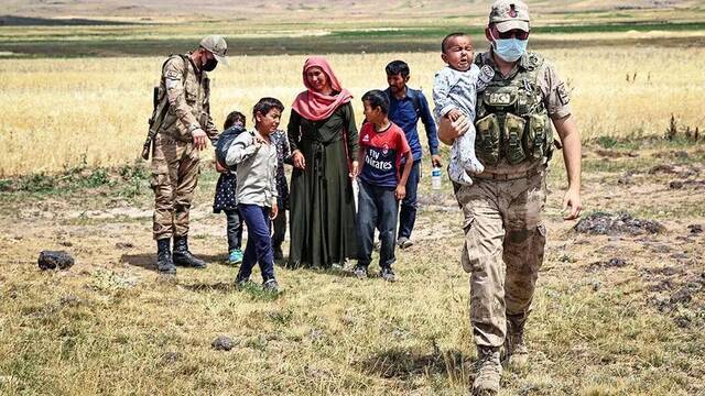 在土耳其边境巡逻的安全部队与阿富汗难民。图据外媒