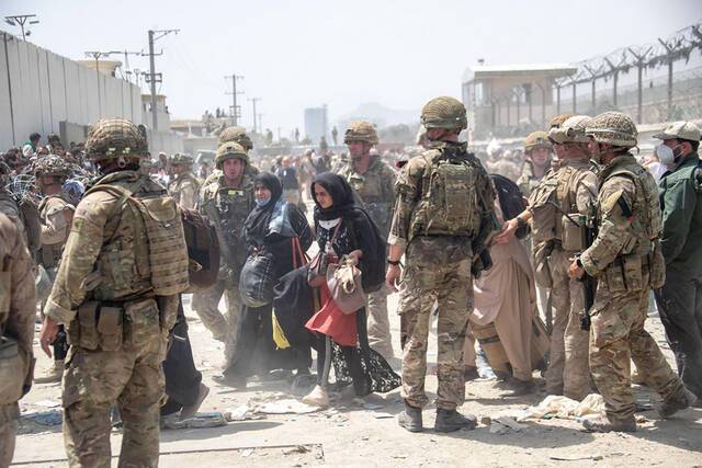 ↑英国部队正与美国军方合作，将符合条件的人撤离阿富汗。