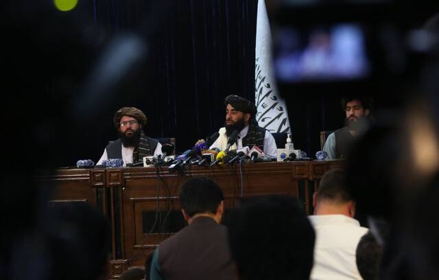8月17日，在阿富汗首都喀布尔，阿富汗塔利班发言人扎比乌拉·穆贾希德（后中）在塔利班进入喀布尔后举行的首次记者会上表示，塔利班计划在阿富汗组建一个包容性政府。（新华社发）