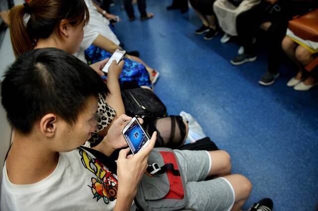 一名乘客在地铁车厢内玩手游。新京报记者郑新洽摄