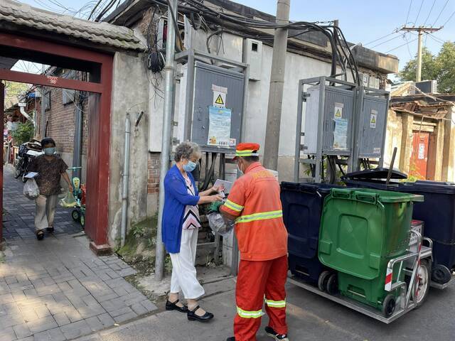 精忠社区物业保洁人员定时定点接收居民垃圾。新京报记者王贵彬摄