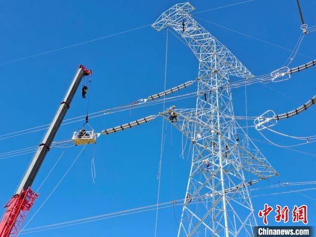 图为施工人员在高空进行压接工作。邹建华摄