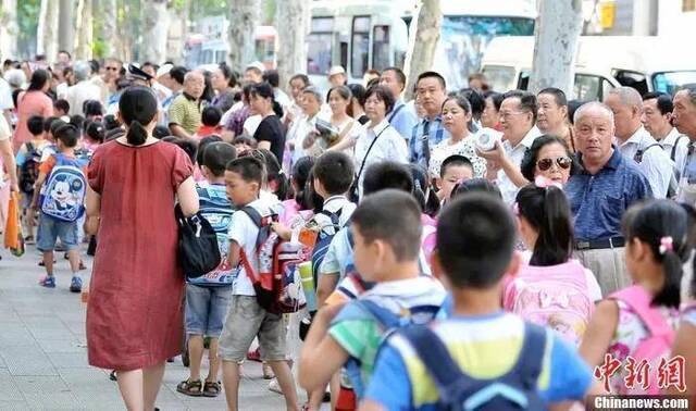 资料图：武汉一小学门外家长接孩子放学。中新社发张畅摄