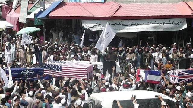 阿富汗塔利班支持者“抬棺游行”庆祝美军完全撤离，棺材被盖上美英法国旗和北约旗帜
