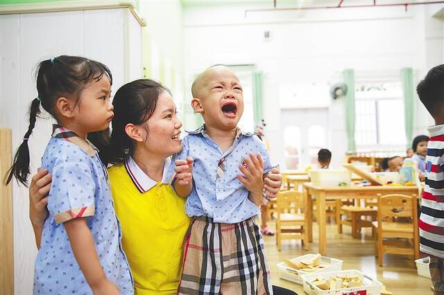 ③9月1日，海口中小学和幼儿园如期开学。在海南省农垦总局机关幼儿园，部分刚入园的小朋友因和家长分离而哇哇大哭，老师耐心安慰哭泣的孩子。海南日报记者 陈若龙 摄