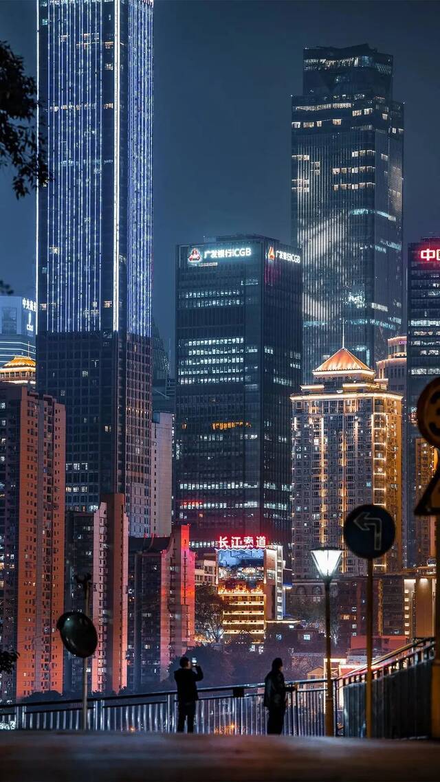 在充满赛博朋克感的城市背景下，两位观赏夜景的市民仿佛成为了画面中的主角，看起来既真实又科幻。张坤琨摄