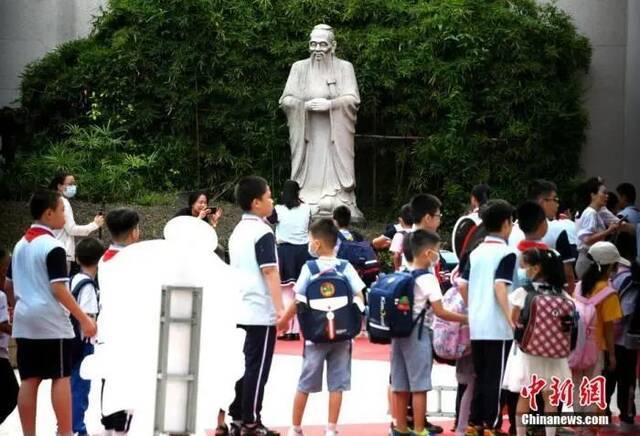 资料图：福州钱塘文博小学，学生经过校园里的孔子雕塑并鞠躬。王东明摄
