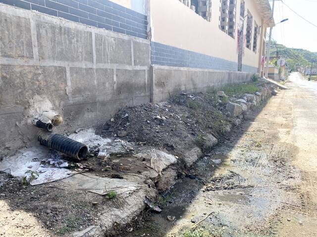 （娄烦县静游镇峰岭底村，临街住户将生活污水直排街面上。新华社记者摄）