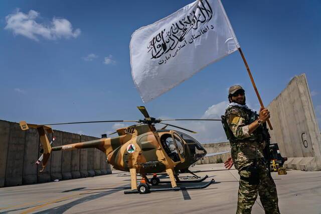 当地时间2021年8月31日，喀布尔，阿塔成员在机场挥舞着塔利班白色旗帜。
