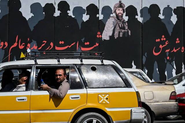 当地时间2021年9月5日，喀布尔，汽车经过巨幅塔利班宣传画。