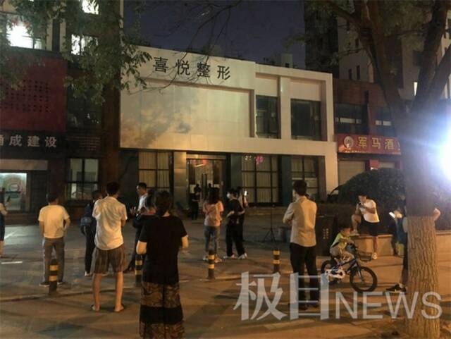 9日晚，警方发布最新通报后，聚集在喜悦整形店前的市民。极目新闻记者摄