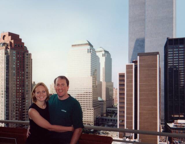 “9·11”事件前，克里斯蒂娜·斯坦顿及其丈夫在其家中以双子塔为背景的合照。受访者供图