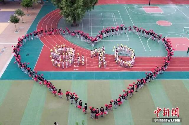 资料图：山西太原小学生摆成巨型心形图形与9.10字样图案，庆祝即将到来的教师节。张云摄