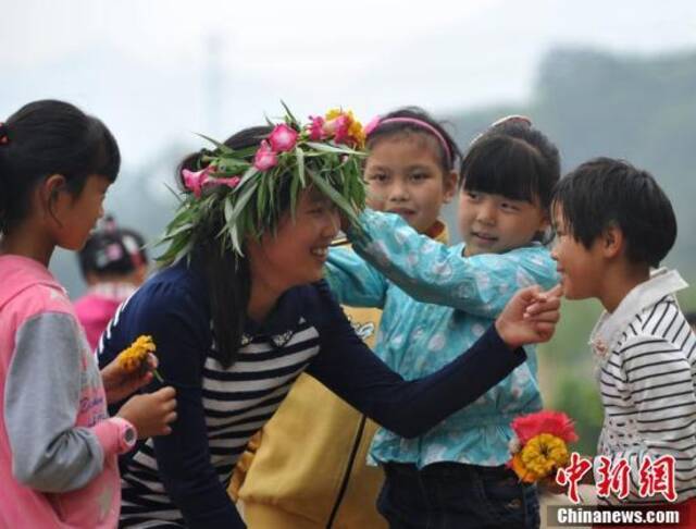 资料图：孩子们亲手编花环祝贺老师节日快乐。中新社记者翟羽佳摄