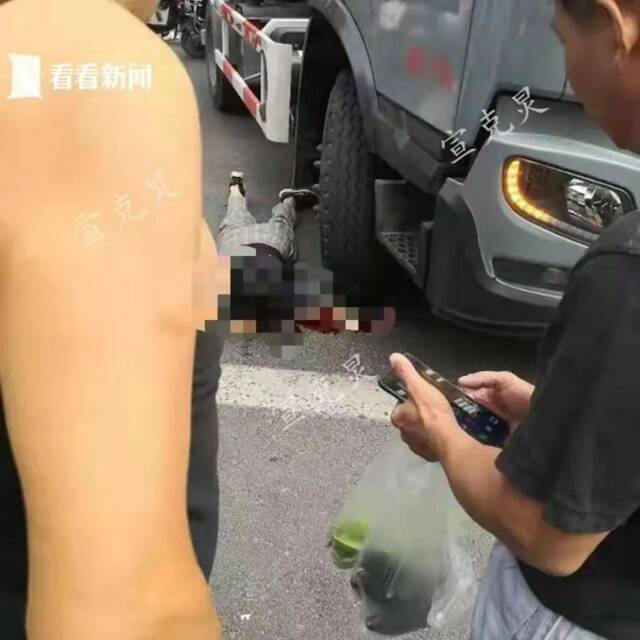 上海一名骑行人被大车撞倒，数十市民援手抬车，伤者手臂……