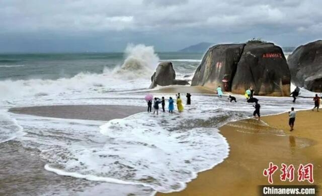 图为近日在三亚天涯海角旅游区嬉浪的游客。游建行摄