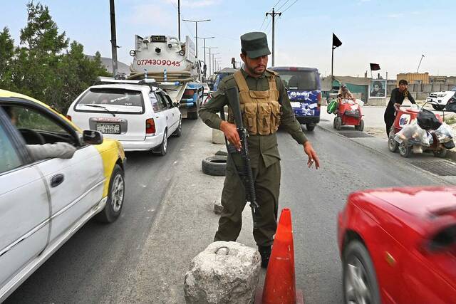 阿富汗警察在喀布尔路边的一个检查站站岗。（资料图）