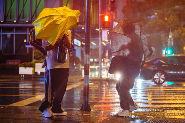 2021年9月13日，上海，河南路宁波路路口，行人的伞被风吹飞。