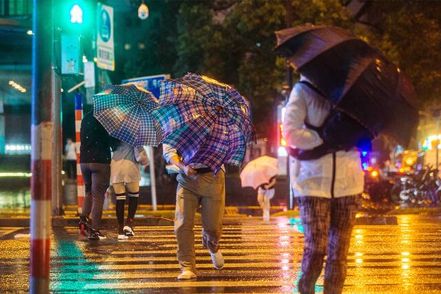 2021年9月13日，河南路宁波路路口，市民在风雨中出行。