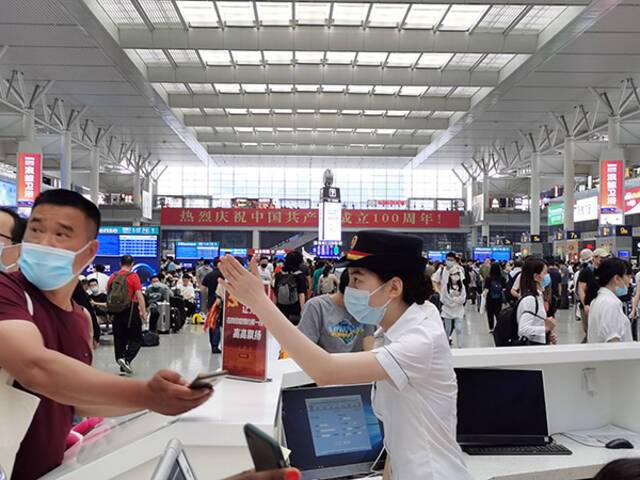 上海虹桥站工作人员为旅客提供咨询和引导服务。
