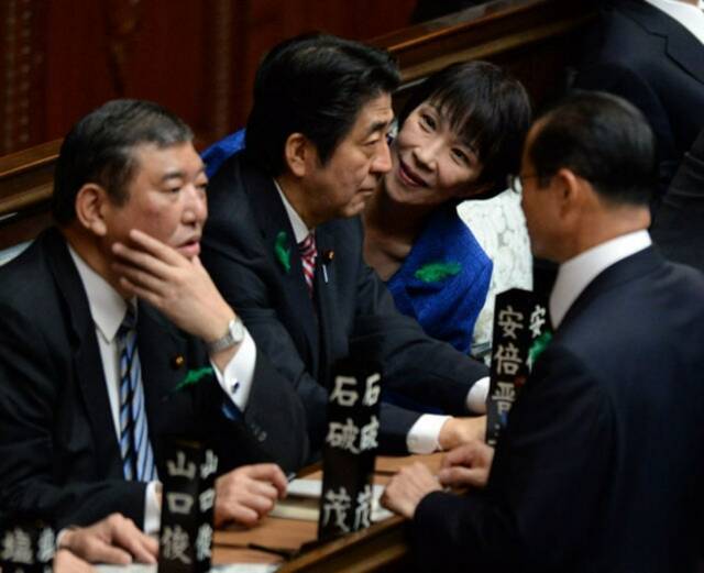 2015年4月，在日本国会众议院，时任日本首相安倍晋三（左二）与时任总务大臣高市早苗（右二）商谈。