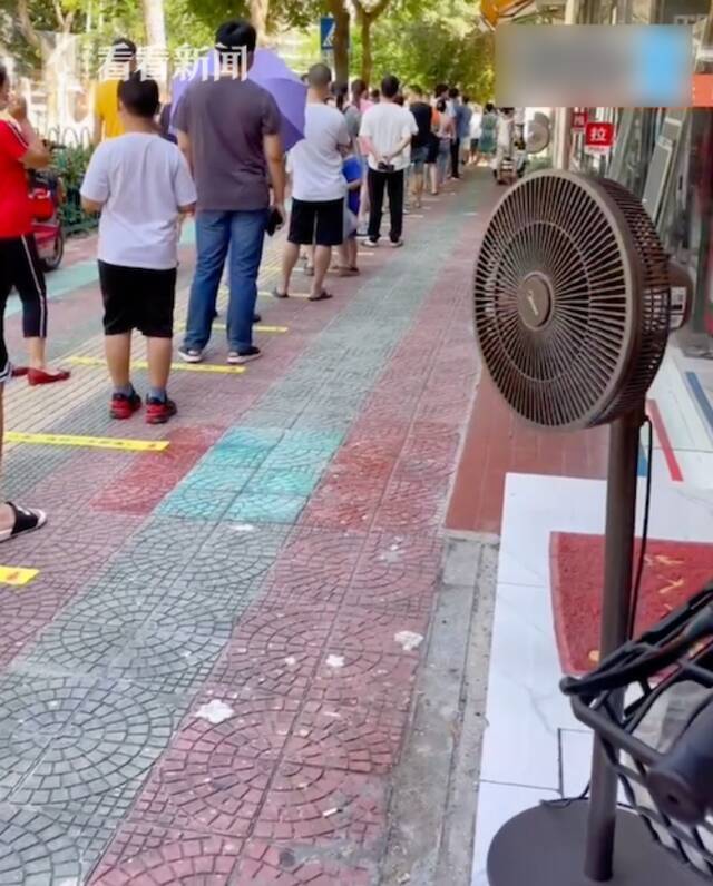 市民排队核酸检测 沿途店家主动摆出风扇送清凉