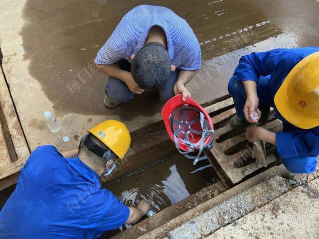 督察组工作人员在污酸处理车间雨水管道取样进行检测